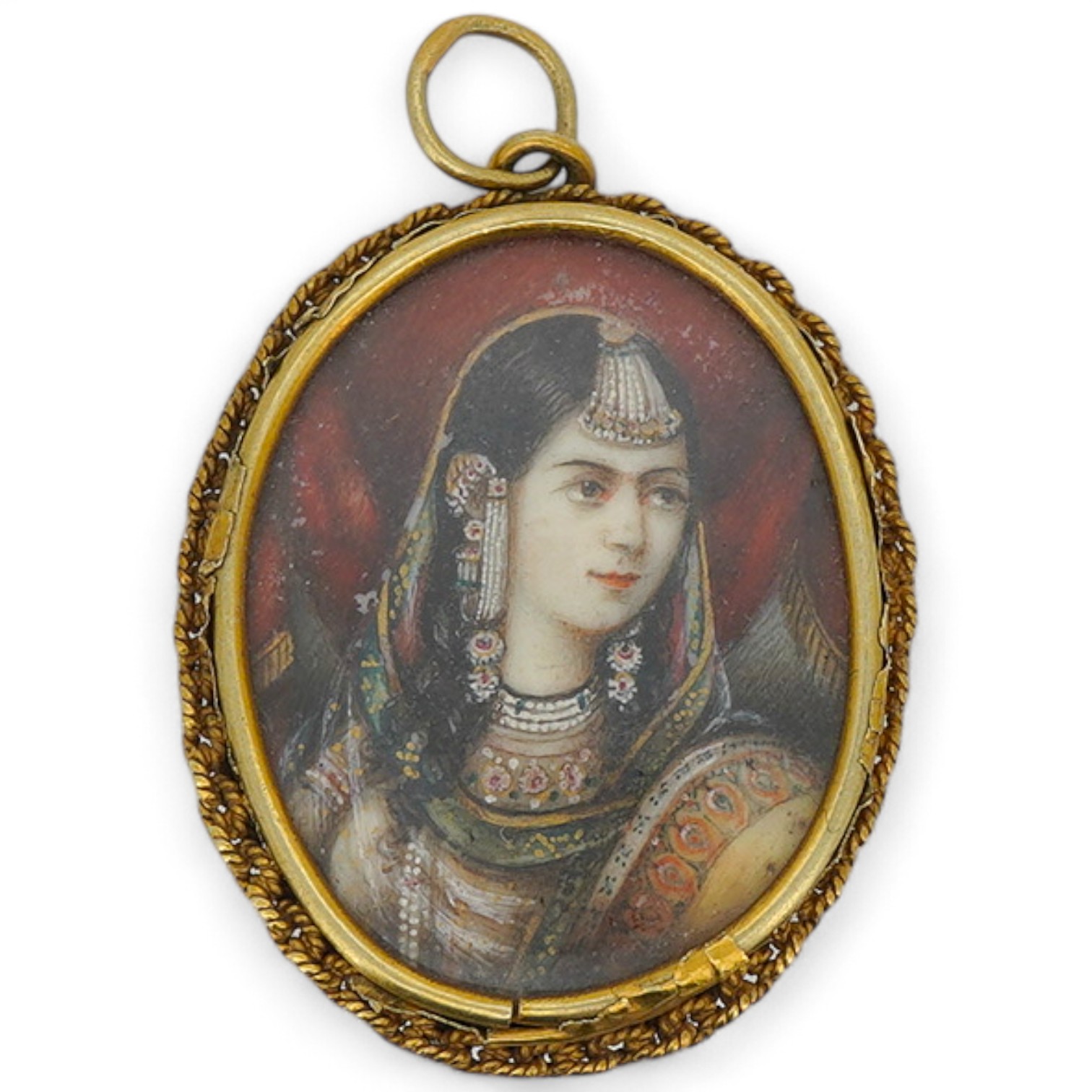 An ivory portrait miniature pendant, India, 19th century, depicting a woman in Mughal dress, in a gold mount with a rope twist chain border, to a pendant hoop, length 3.9cm, back damaged, later brooch fitting with pin de